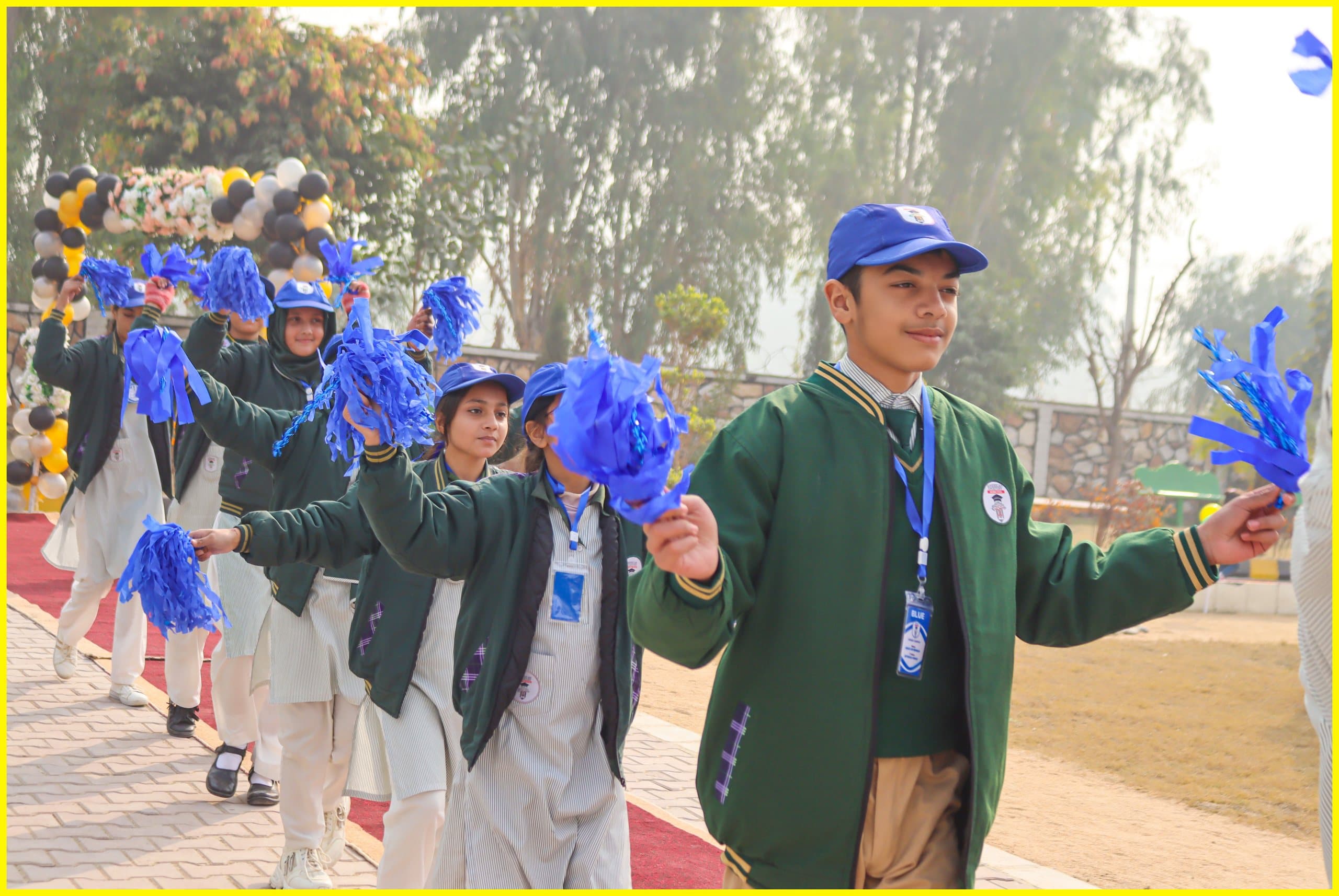 Students cheering with blue pom-poms during a school parade