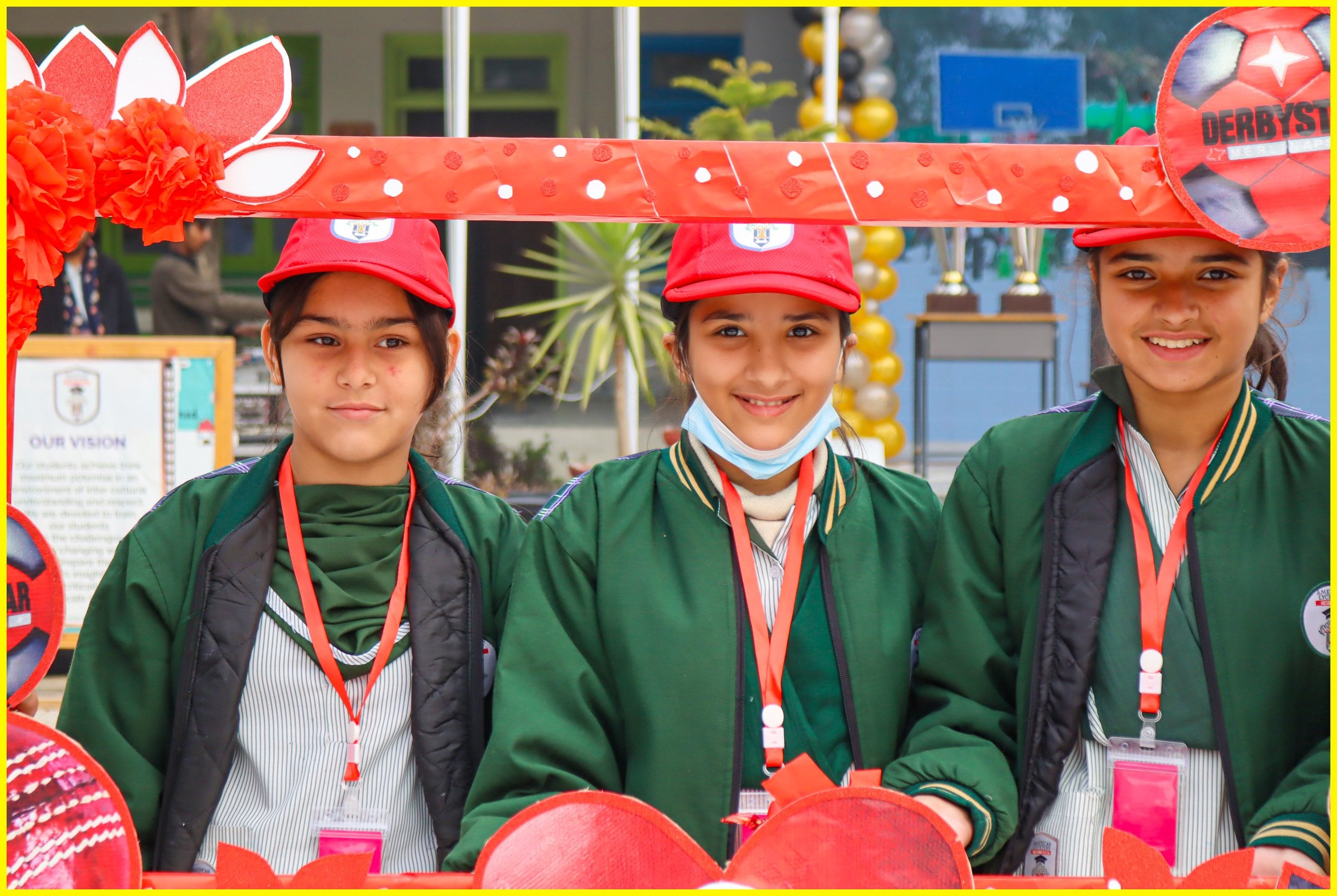Primary school girls in red caps smiling at a school event