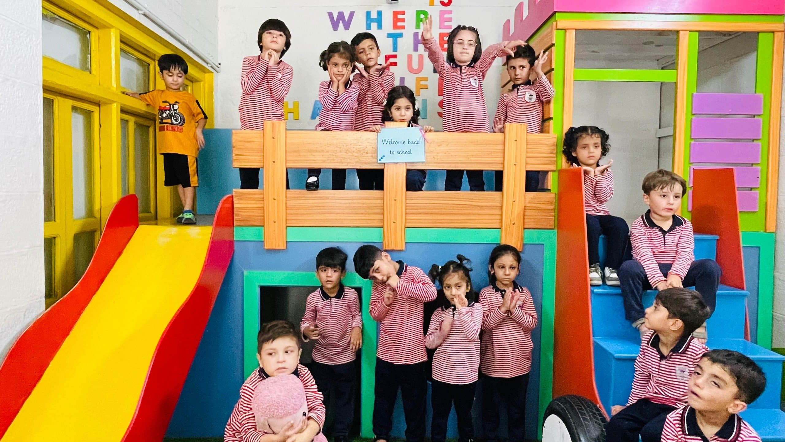 Young students in pink uniforms on the play structure of an early years classroom