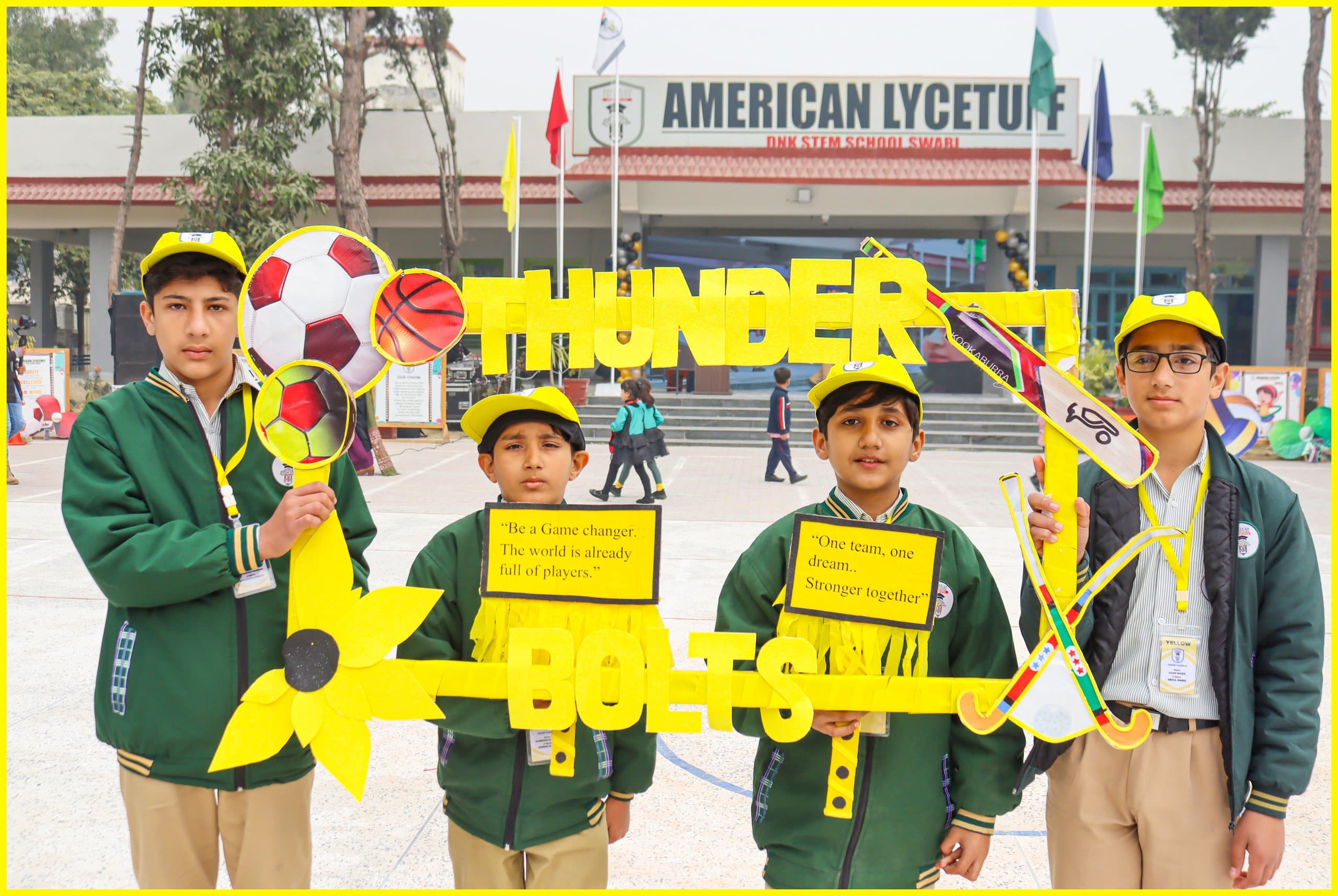 Students holding a Thunder house banner in front of the school