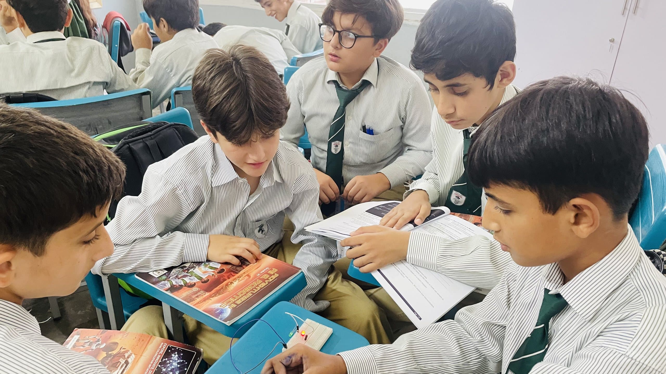 Students reading an experiment worksheet together during a science practical