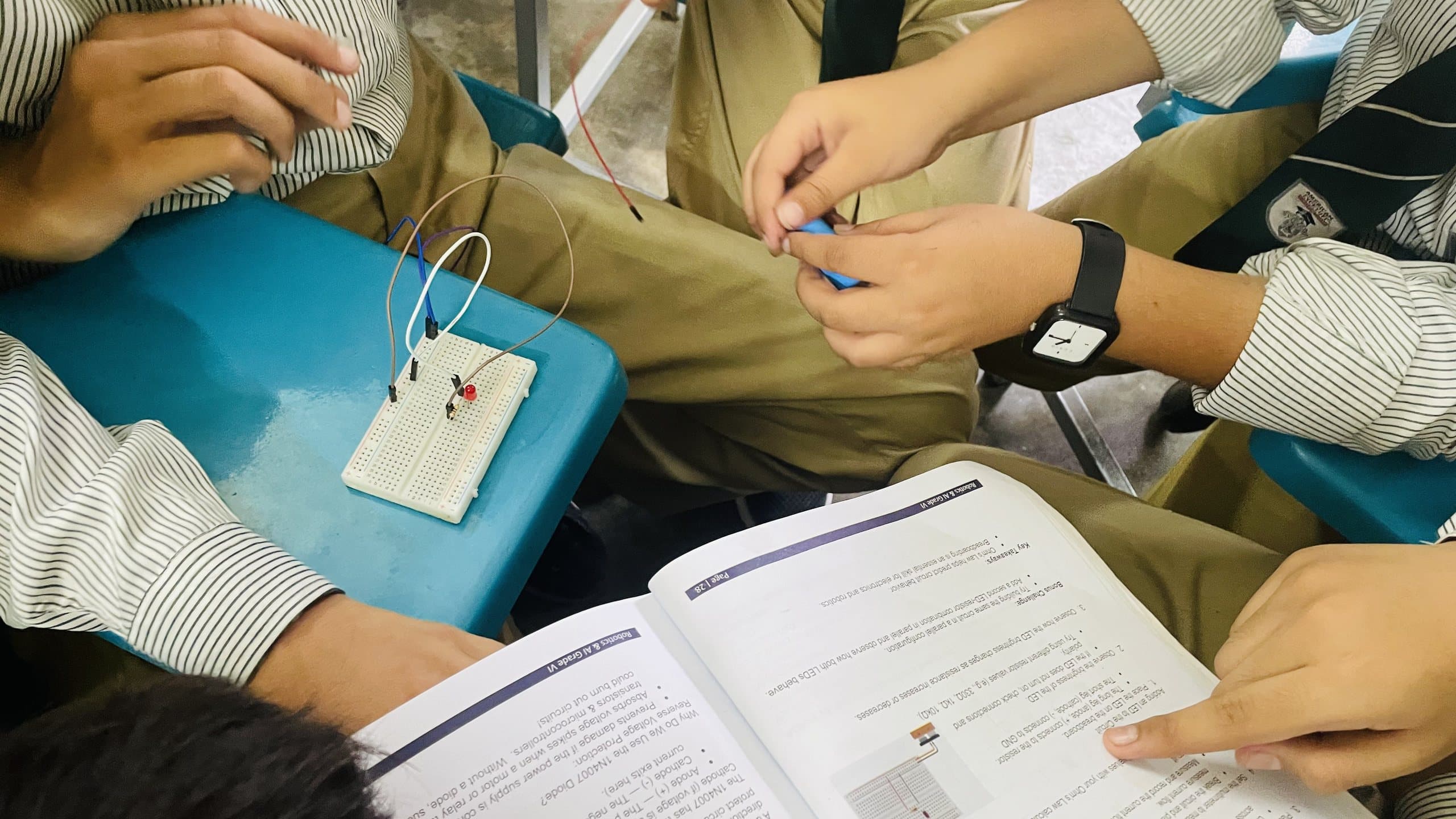 Young students connecting an LED circuit on a breadboard
